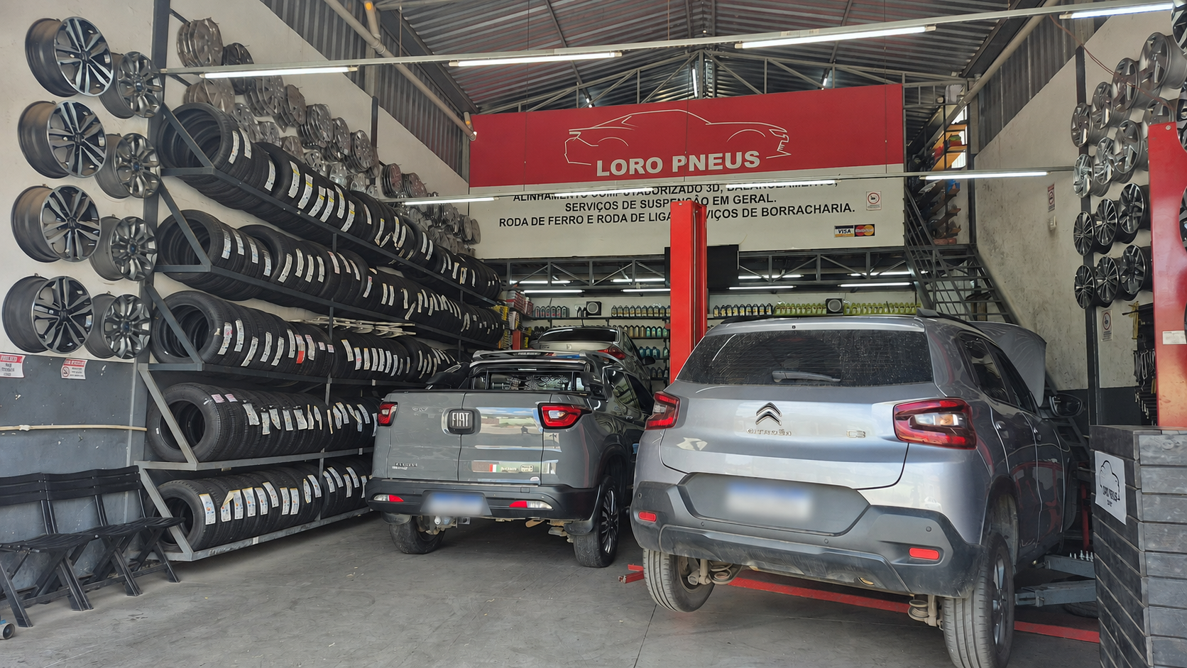 Atendimento dentro da oficina Loro Pneus Igarapé, com placas ocultadas